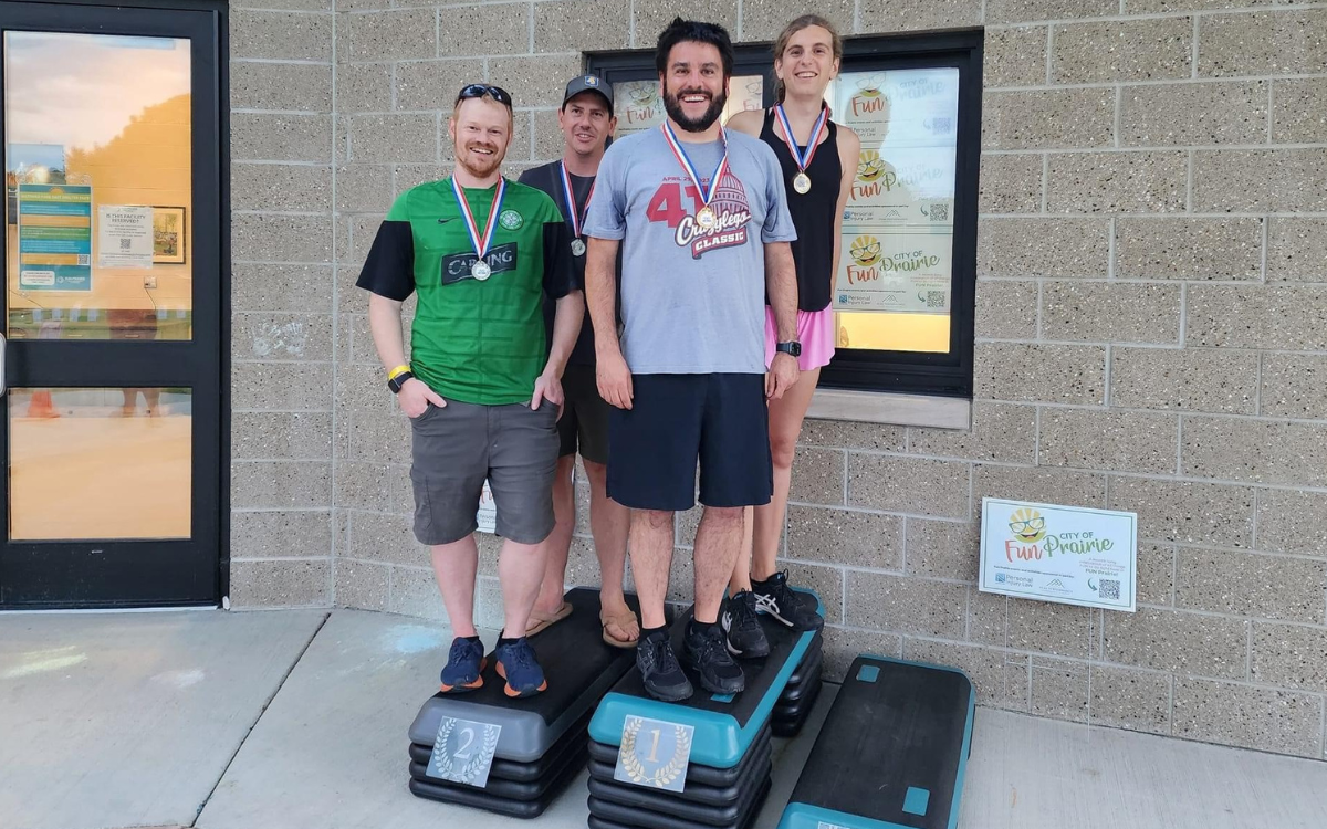Pairs of adults stand on a podium